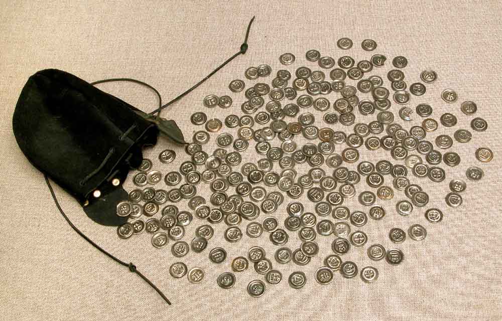 Kilkadziesiąt drobnych monet rozsypanych z leżącej obok czarnej skórzanej sakiewki.