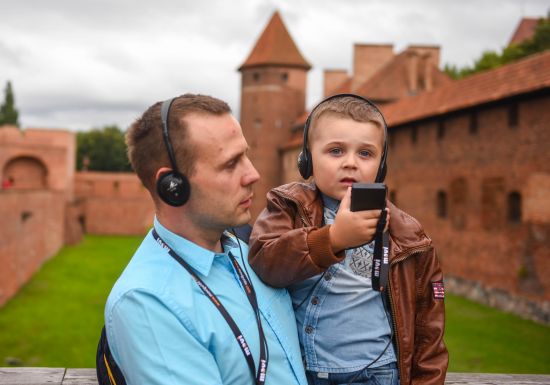 Turyści zwiedzający zamek z audioprzewodnikiem