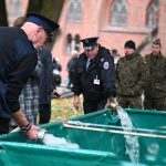 Dziedziniec zamku średniego. Pracownicy muzeum napełniają zbiornik wodą.