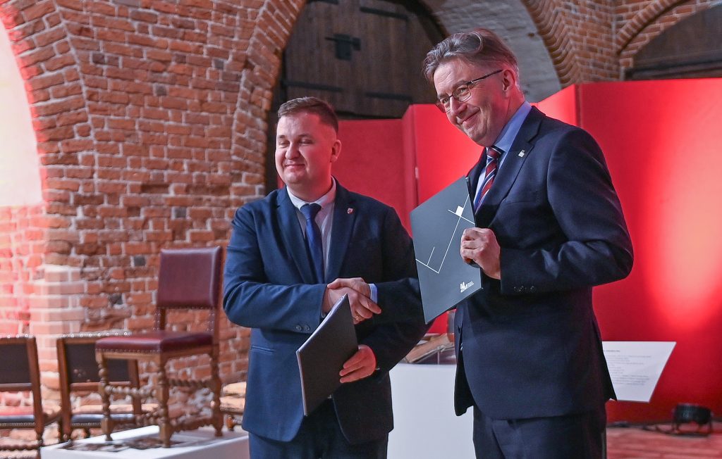 Dyrektorzy Janusz Trupinda i Tomasz Agejczyk wymieniają podpisane dokumenty.